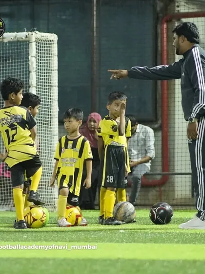A coach instructs his youngest players, who are listening intently. I make sure even our little ones get professional, focused coaching.