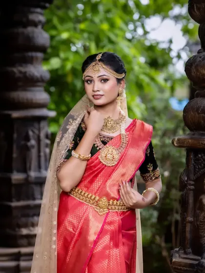 A full-length view of a bride wearing a complete temple jewellery set. This helps you visualize how the jewellery complements the entire outfit, from head to toe.