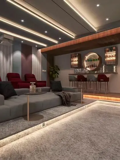 This entertainment space combines a home theater with a built-in bar at the back. The tiered seating and ambient floor lighting create a luxurious, cinema-like atmosphere.