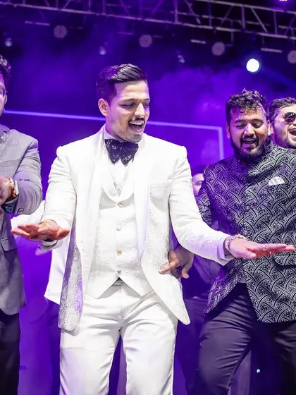 A close-up of the groom and his groomsmen enjoying their dance performance on stage.
