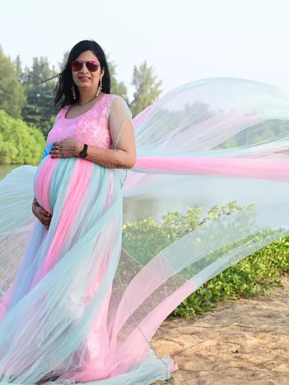 This unique rainbow trail gown is perfect for a fun and colorful beach maternity shoot, celebrating your journey in style.