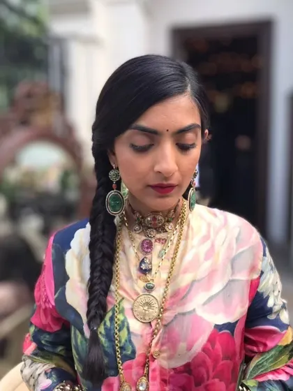A front view of the fishtail braid, showing how it can be paired with statement jewelry for a complete, fashion-forward look.