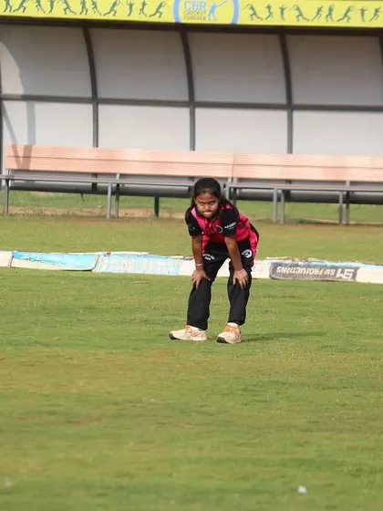 A young fielder gets ready in the field, learning about positioning and awareness.