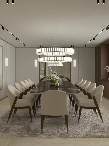 This formal dining room is designed for hosting in style. A long table is flanked by upholstered chairs under dramatic circular chandeliers, creating a space that is both impressive and intimate.
