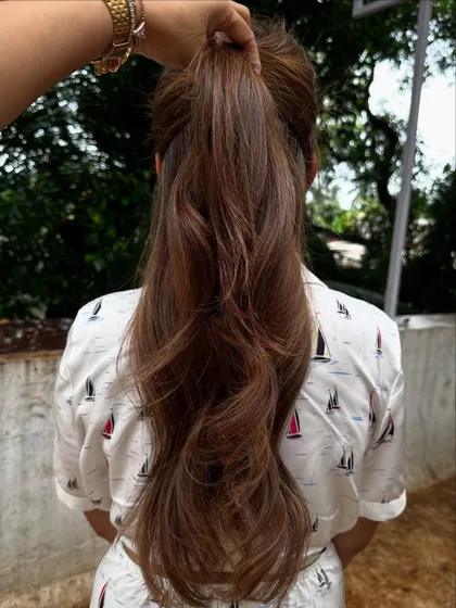 Holiday hair with a beautiful balayage, shown in a ponytail.