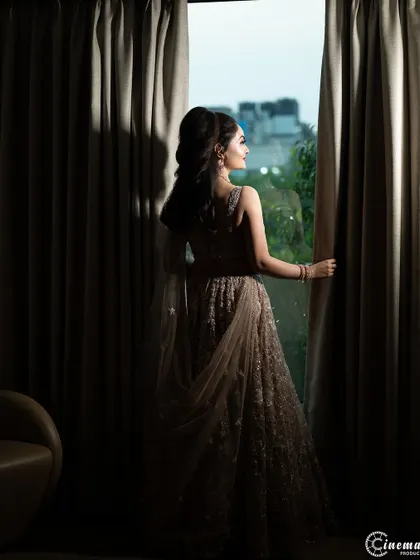 An atmospheric shot of the bride looking out the window, creating a sense of anticipation and quiet reflection.