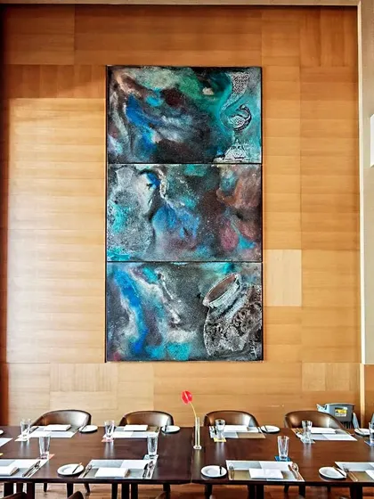 A stunning triptych by artist Adil Writer, titled 'Feast', displayed in a private dining area at the Sheraton. This demonstrates how we integrate art to elevate the ambiance of luxury hospitality spaces.