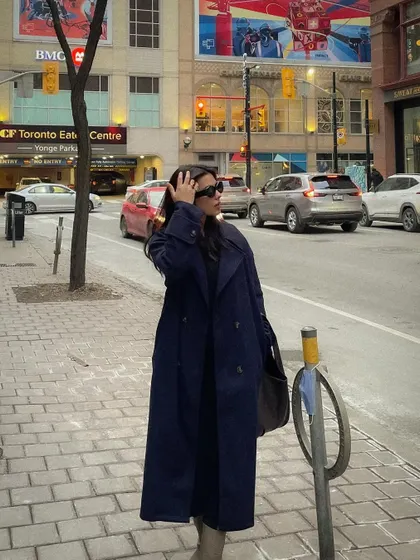 A street-style photo featuring the long navy Shein coat on a Toronto city street.