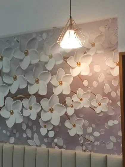 A 3D floral mural with large white blossoms. The embossed effect of this wallpaper adds a tactile and visual depth that makes the wall stand out.