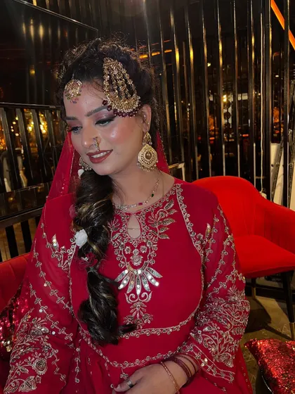 A close-up shot focusing on the bride's smile and the intricate details of her makeup. The soft smokey eye, defined lip, and glowing skin come together to create a look of happiness and beauty.