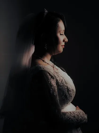 An artistic, low light portrait of the bride in profile, creating a serene and contemplative mood.