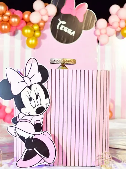 A cute Minnie Mouse theme in classic pink and white polka dots. The setup includes character cutouts and themed pedestals.