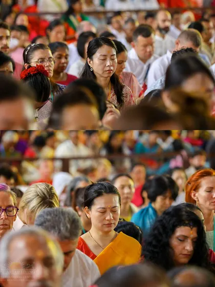 A diverse group of participants from around the world meditating together. The experience of collective silence and meditation transcends cultural and language barriers, uniting everyone in a shared space of peace.
