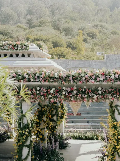 Another view of the stunning floral-covered mandap set against the lush green backdrop of Nandi Hills. We designed the structure to feel like it was a natural part of the landscape, just bursting with color.