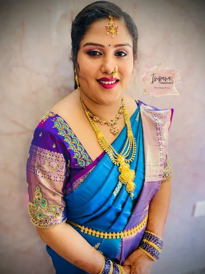 The client's happy smile shows her satisfaction with the final look. The complete styling service includes makeup, hair, and saree draping.