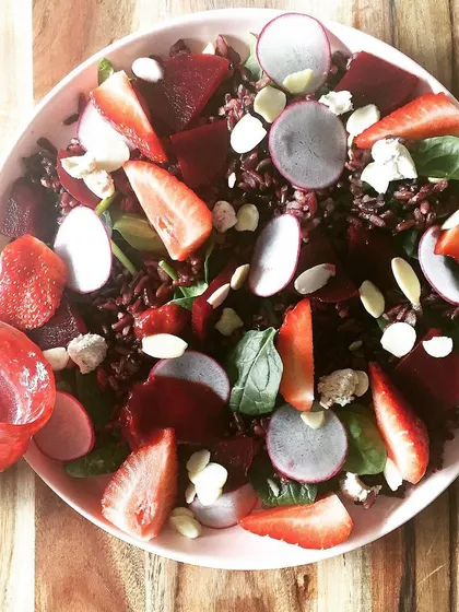 A colorful black rice salad with strawberries and beets, another example of a meal designed to support brain health.