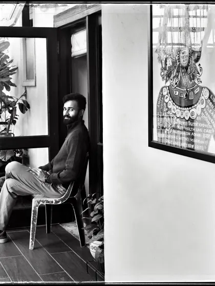 Tejas, seated in a doorway. The contrast between the bright outdoors and the darker interior creates a compelling frame for this portrait.