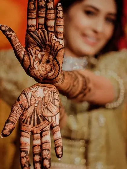 A creative pose showing the bride and groom portraits on each hand. This style of mehandi is very popular and makes for amazing wedding photos.