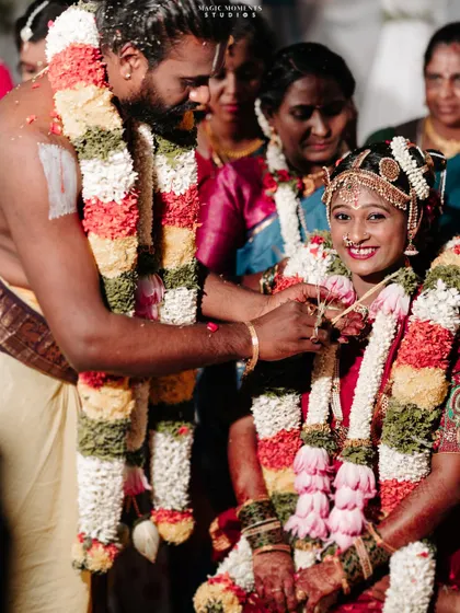 The groom tying the mangalsutra around the bride's neck. Her joyful smile makes this a heartwarming and essential shot.