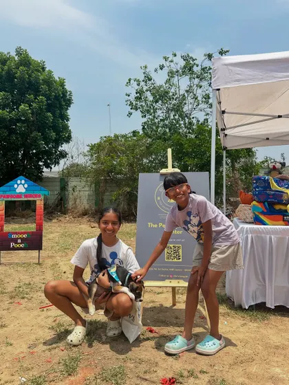 Two young visitors posing with a puppy at our photo booth. Creating happy memories is part of the adoption experience we aim to provide.