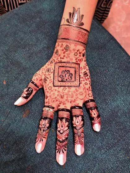 A close-up of an instant mehandi design. The lotus motifs on the fingers and the central pattern have a beautiful, dark color that is perfect for parties and festivals.