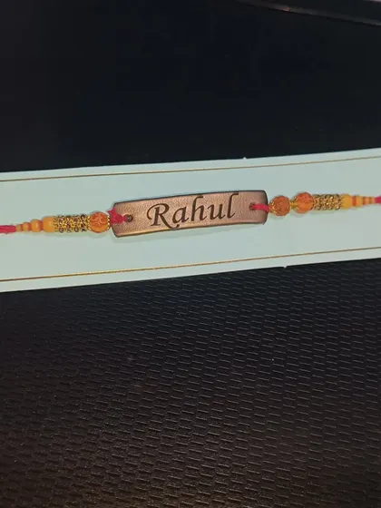 A close-up of my custom vegan leather Rakhi, engraved with the name 'Rahul'. A personal touch for your brother.
