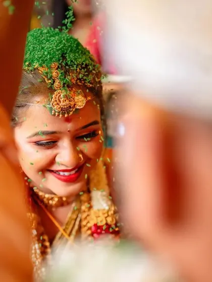 A close up of a bride's reaction during the Talambralu ritual, where rice or seeds are poured over her head. A moment of pure joy and tradition.