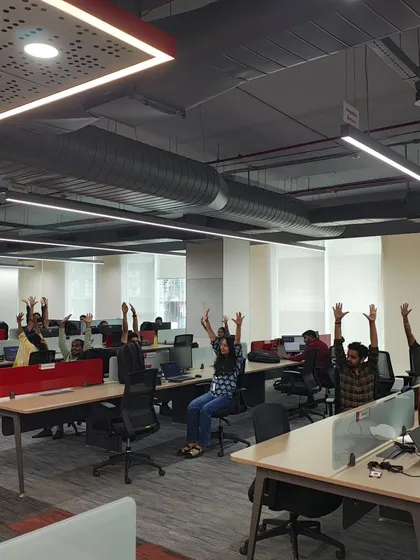 Employees at their desks raising their arms in a guided stretch, bringing a burst of energy and improved circulation.