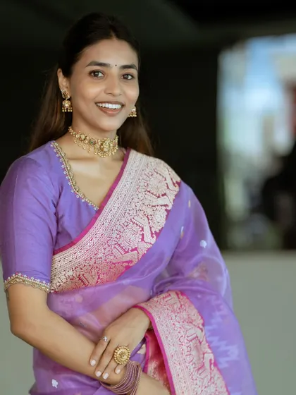 A close-up look at the elegant purple saree outfit, highlighting the custom blouse and gold jewelry.