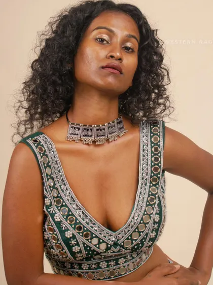 A powerful close-up of the green Shisha blouse, where the model's strong expression matches the boldness of the design. This type of shot is perfect for showcasing beauty, makeup, and the intricate details of a garment.