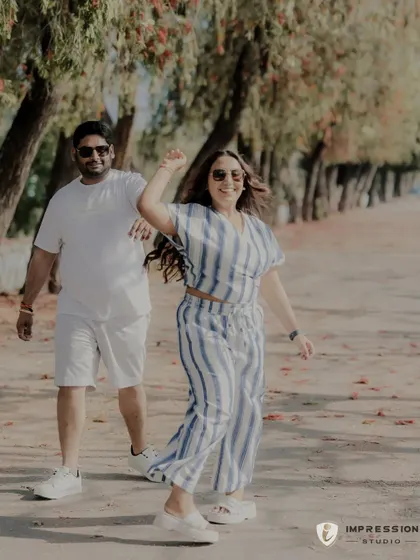 A candid shot of the couple walking and dancing together. Their coordinated outfits and happy expressions make this a perfect lifestyle portrait, capturing their natural chemistry and shared rhythm.