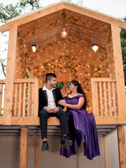 A magical, starlit moment in a treehouse. The rich purple of the bride's gown and the groom's dark suit create a romantic and dreamy scene.
