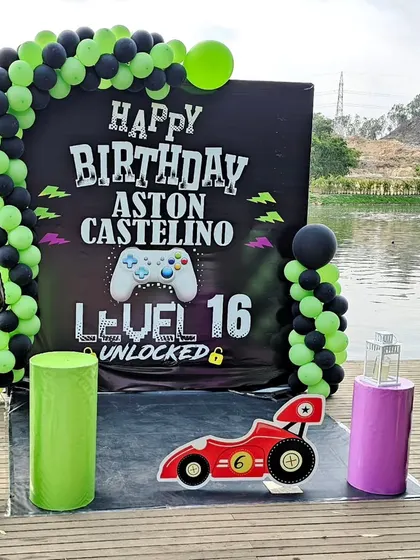 For the older kids, a video game-themed "Level Unlocked" birthday party. The decor includes a giant controller, neon green and black balloons, and personalized signage.