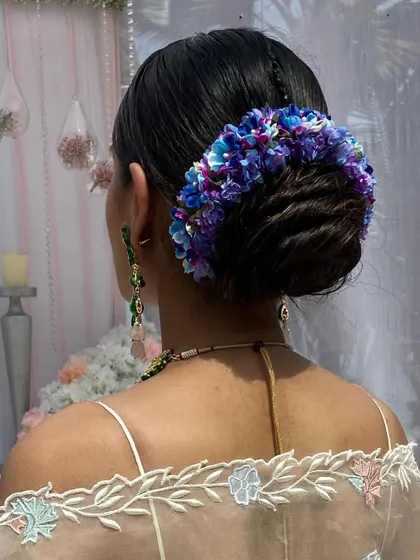 A close-up of the blue and purple floral bun, showing the rich colors and textures.