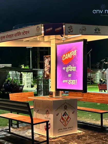 Our Smart Solar Hut at Siddhi Park near Hanuman Garhi, fully illuminated at night. The vibrant Campa advertisement on the digital screen is clearly visible, showcasing the effectiveness of our OOH network for 24/7 brand promotion.