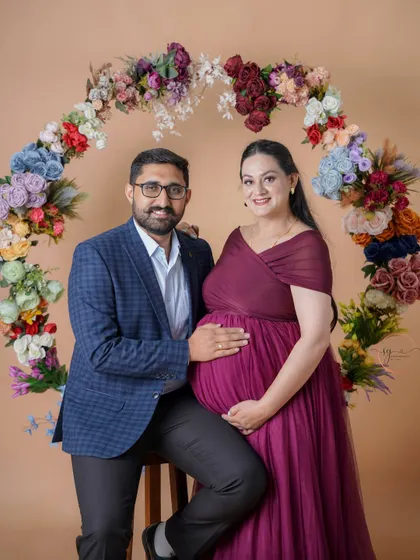A happy couple portrait framed by our vibrant floral hoop. This setup adds a beautiful burst of color and a celebratory feel to the maternity shoot.