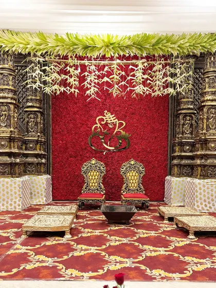 For a truly royal feel, I designed this mandap with a rich red floral backdrop, ornate golden chairs, and traditional pillars, evoking the grandeur of a palace.