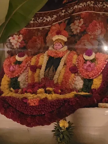 Another style of deity alankaram, set against a floral backdrop.