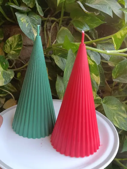 A pair of red and green ribbed Christmas candles.