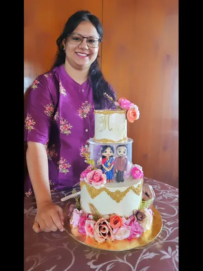 A rare moment when I get a picture with my creation! This was a grand three-tier engagement cake with a spacer, custom figurines, and beautiful floral arrangements.