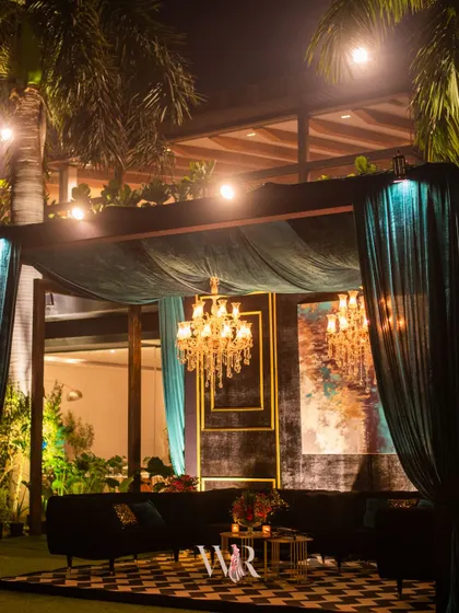 A chic lounge cabana draped in teal velvet, with a bold chevron rug and modern black seating. This setup provided a stylish and semi-private space for guests to relax.
