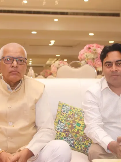 Two male guests seated and posing for a portrait at a banquet hall.