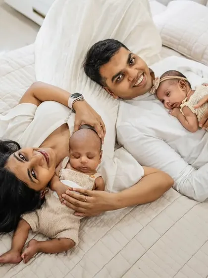 A happy family of four relaxing on the bed. This at-home lifestyle shot with twins is full of joy and natural connection, capturing a perfect family moment.