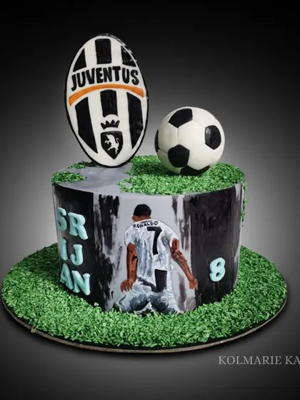 A cake for a Cristiano Ronaldo fan. I hand-painted his iconic celebration pose on the side of the cake, which is topped with a fondant soccer ball and the Juventus logo.