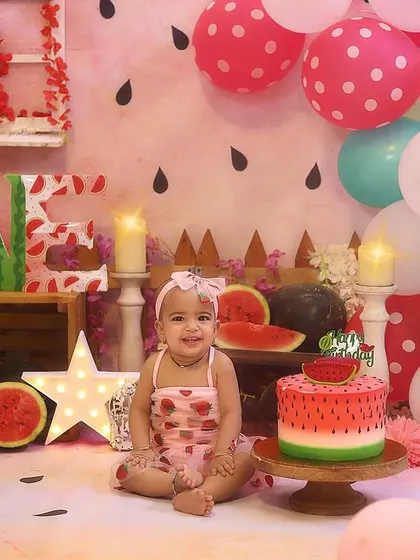 A beautiful portrait with the full "One in a Melon" setup, complete with a watermelon-themed cake and matching 'ONE' letters.