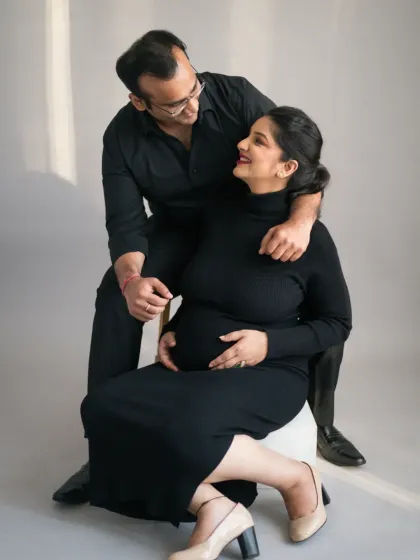 A tender moment between the expecting couple. The way they look at each other speaks volumes about their shared journey and the love that brought them here. This is a classic couples maternity portrait.