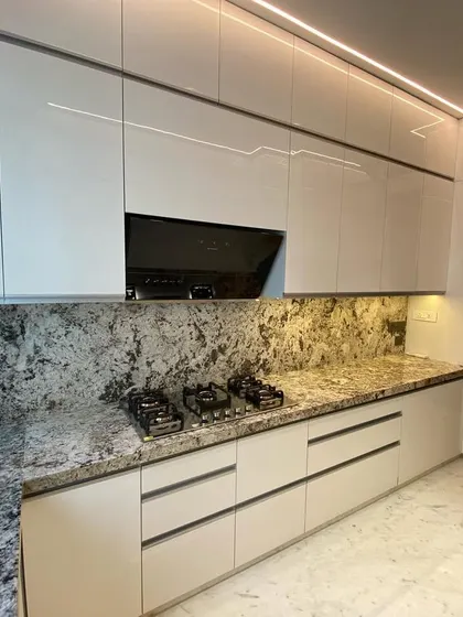 Another angle of the Lodha World Tower kitchen, showing the seamless integration of the hob and chimney. The handle-less design with a J-profile groove maintains the minimalist aesthetic.