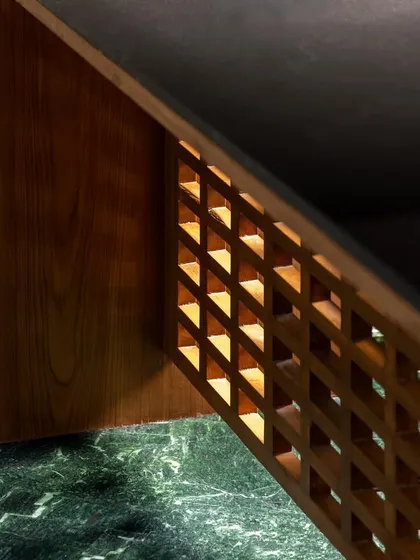 We designed this desk for the Sanctum site office with a built-in light source within its wooden lattice structure. This feature not only provides ambient light but also highlights the intricate craftsmanship of the joinery, turning a functional piece into a design statement.