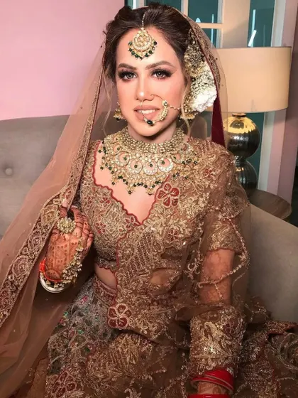 A side profile of the bride, showing the intricate details of her passa and the heavy embroidery on her lehenga.