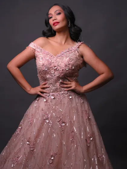 A full-length shot showcasing the beautiful pink gown and how the makeup complements it.